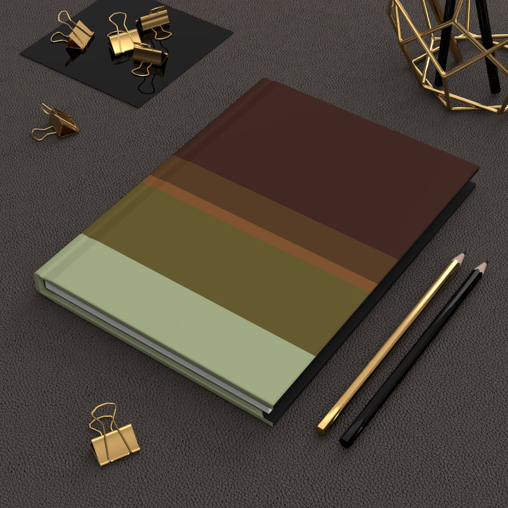 Notebook with gradient cover on a dark surface with office supplies