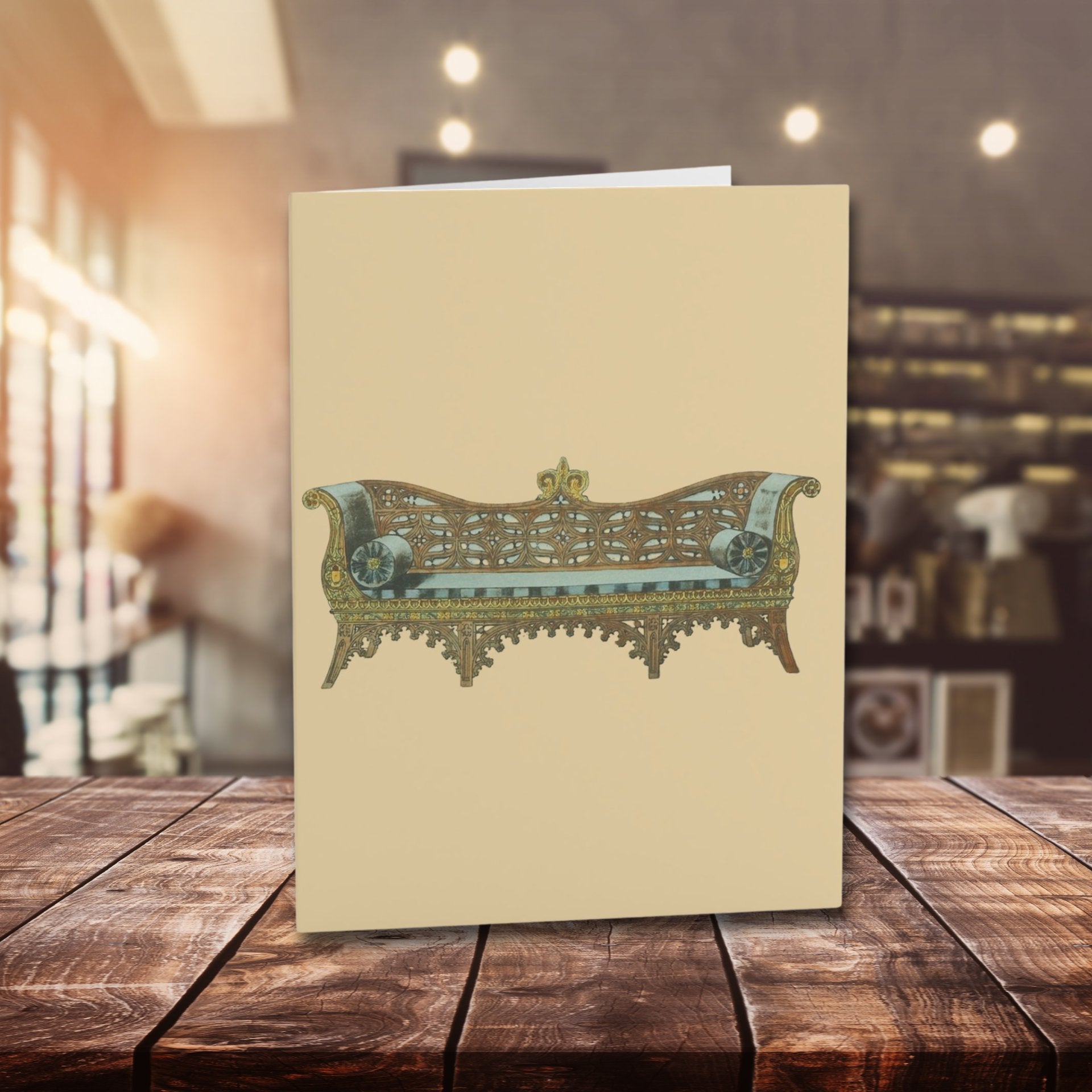 Beige card with decorative couch illustration on a wooden table
