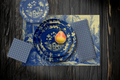 La Chinoiserie Cobalt Party Table — plates stacked on the garden-scene placemat with fretwork napkins, in cream on cobalt, on dark wood