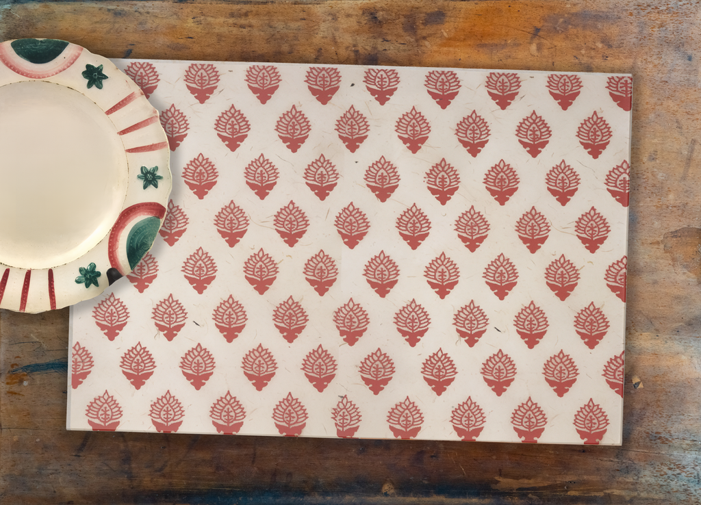Patterned placemat on a wooden surface with a ceramic plate and bowl.