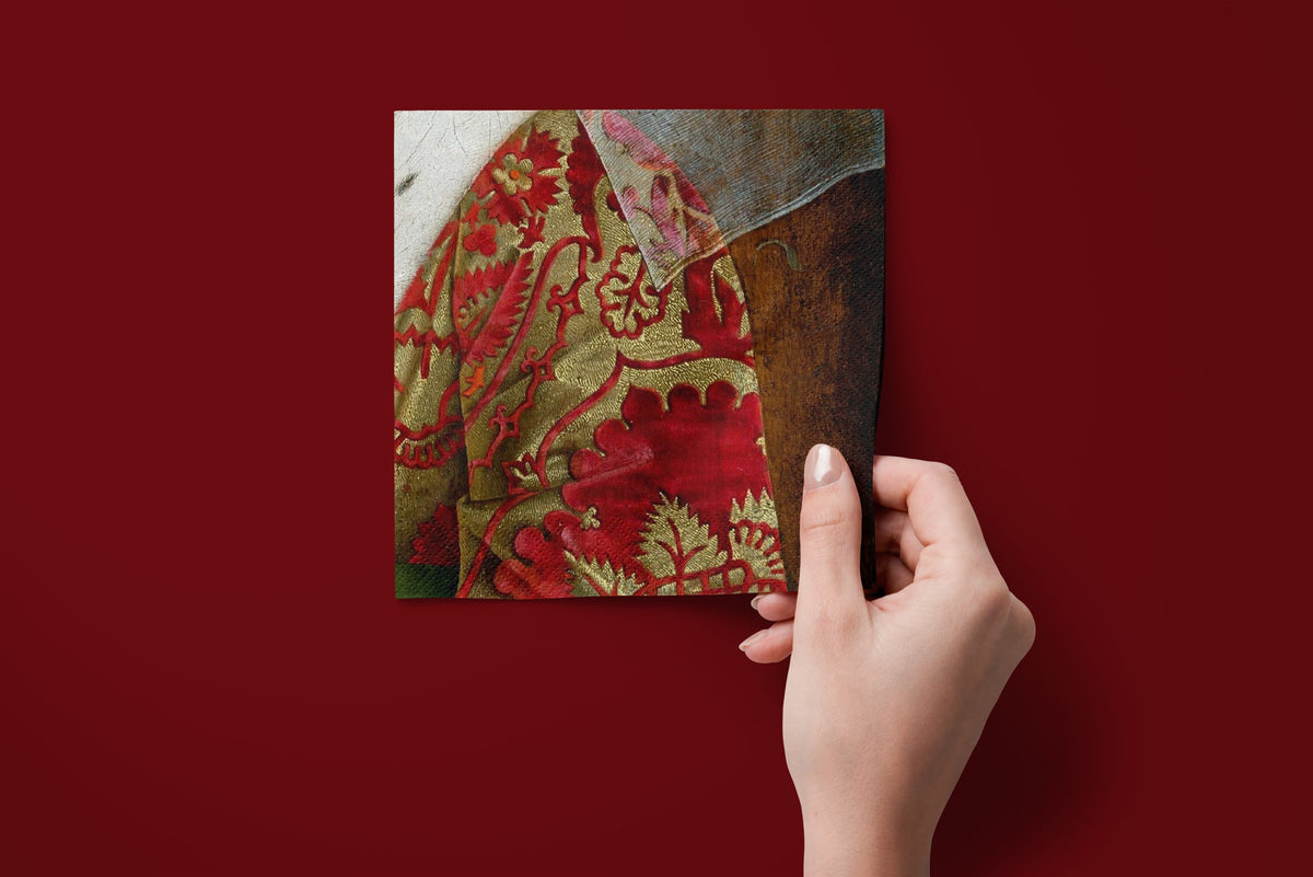 Noël Le Brocart paper napkins on a deep red ground — a napkin held in hand