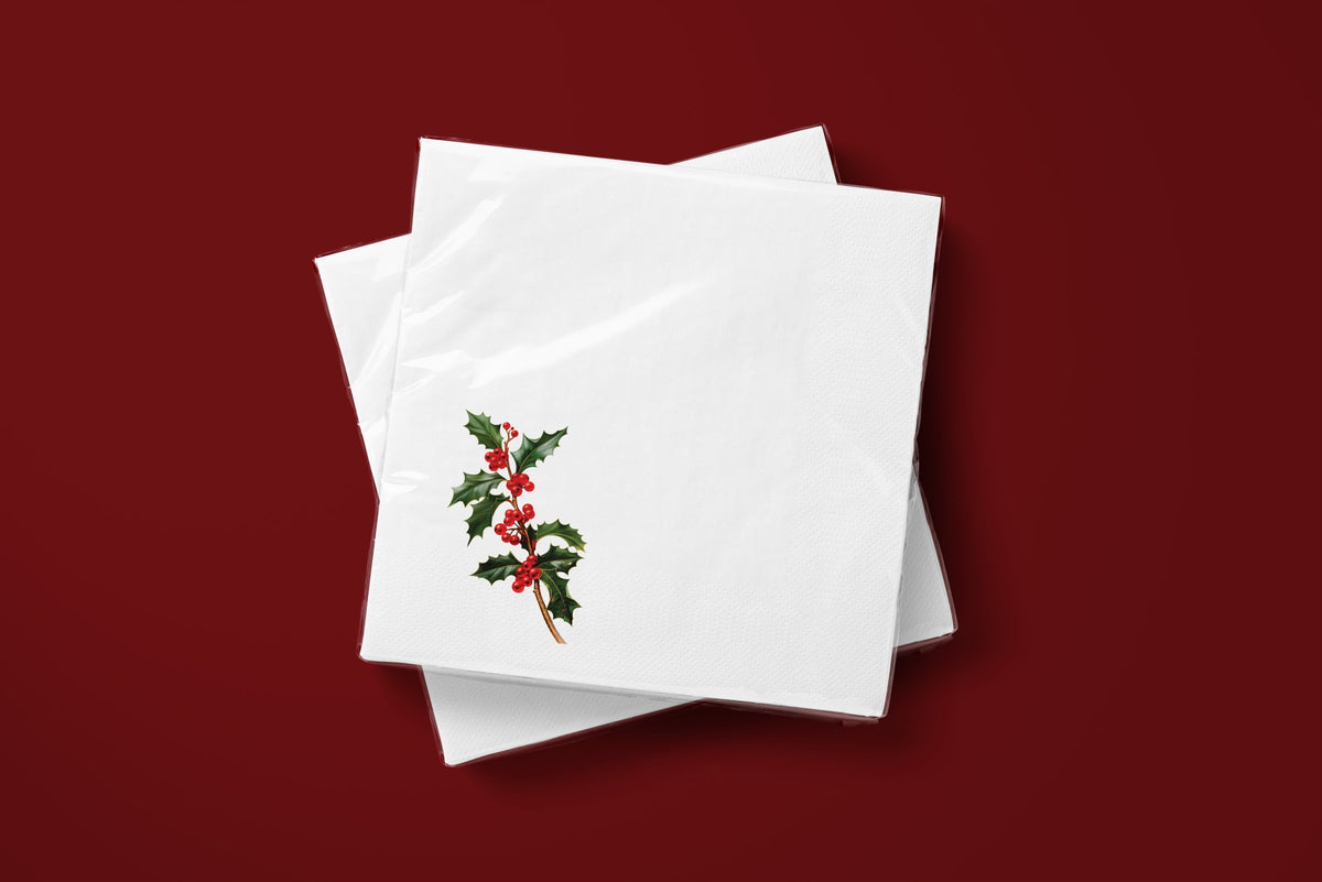 Noël Holly paper napkins on a deep red ground — two napkins stacked