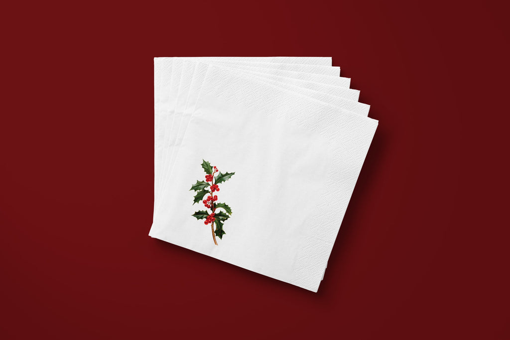Noël Holly paper napkins on a deep red ground — a fanned stack