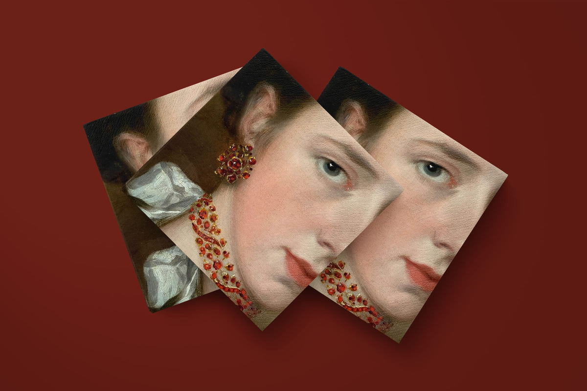 Noël La Parure paper napkins on a deep red ground — three napkins scattered
