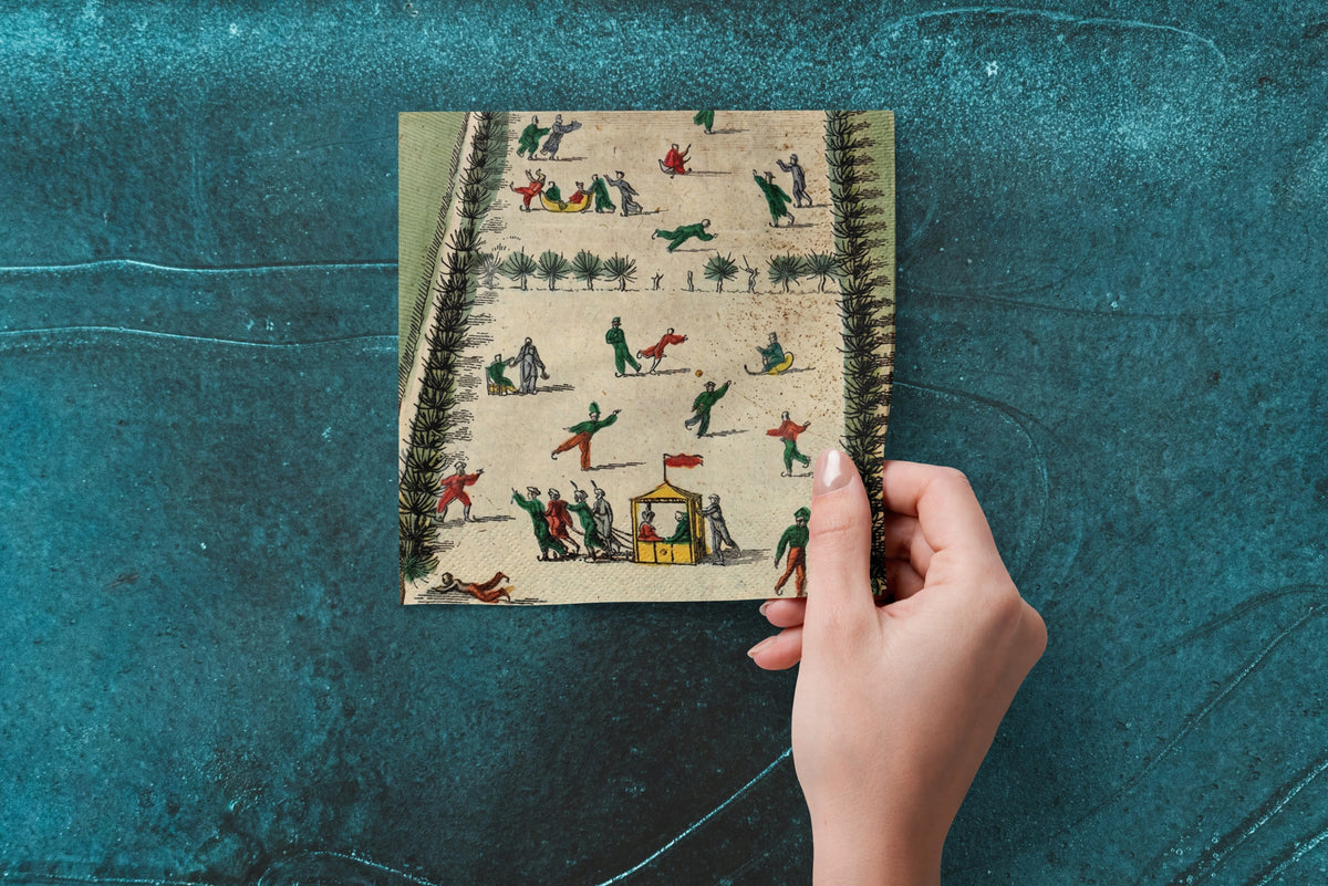 Noël La Patinoire paper napkins on skating-rink ice — a napkin held in hand