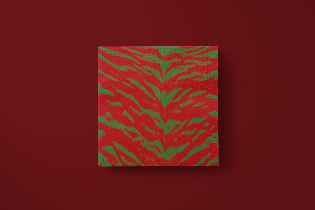 Noël Le Tigre paper napkins on a deep red ground — a single napkin laid flat