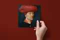 Noël Le Turban paper napkins on a deep red ground — a napkin held in hand
