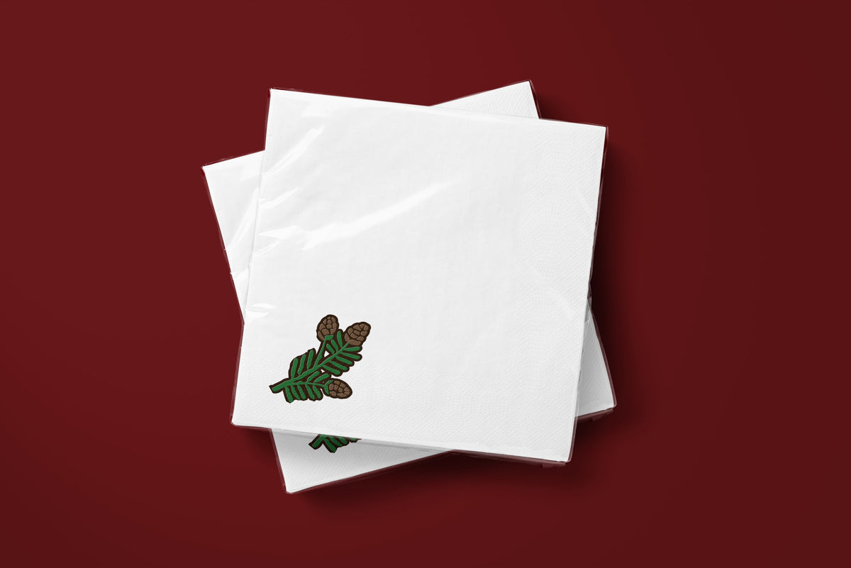 Noël Mini Pinecone paper napkins on a deep red ground — two napkins stacked