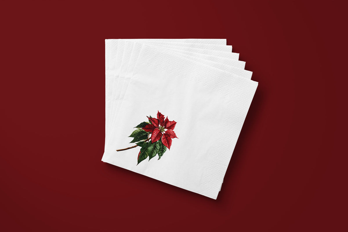 Noël Poinsettia paper napkins on a deep red ground — a fanned stack