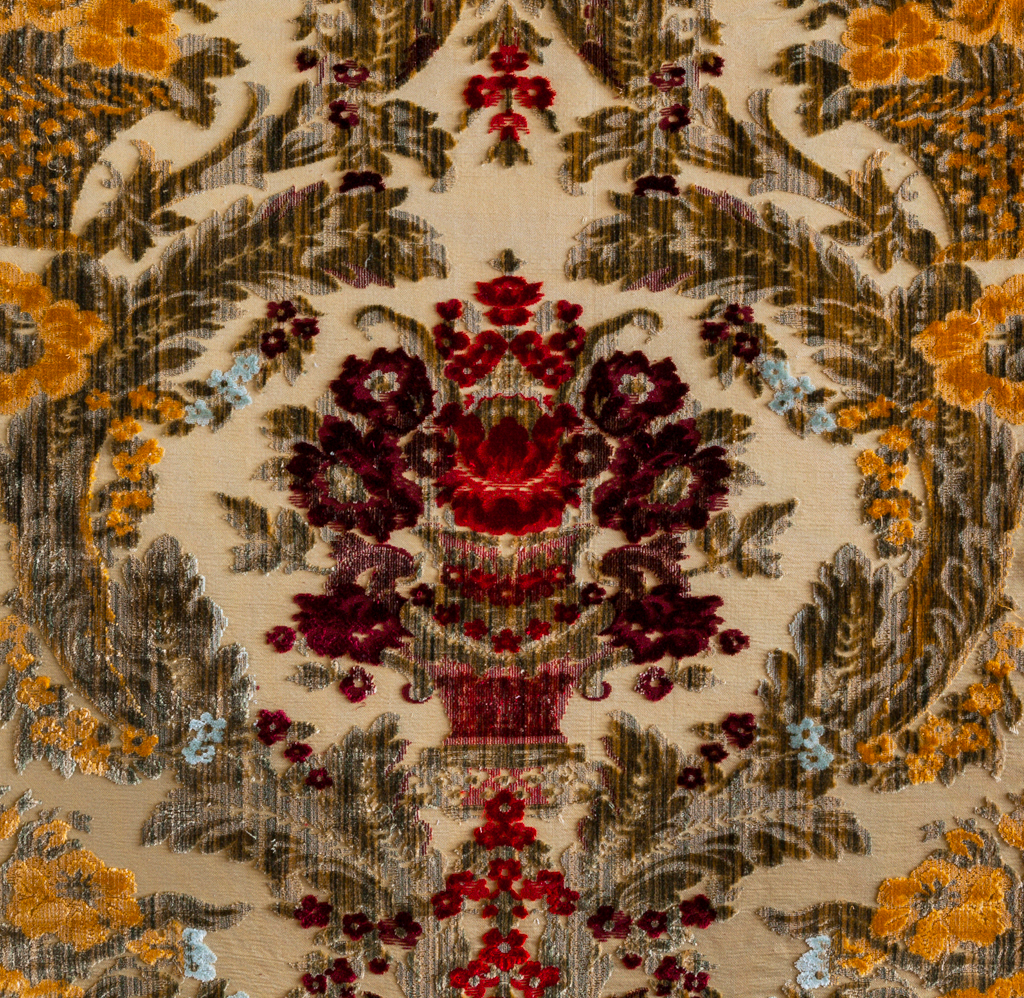 Detail of the Lyon cut silk velvet pattern, crimson flower baskets on a cream ground