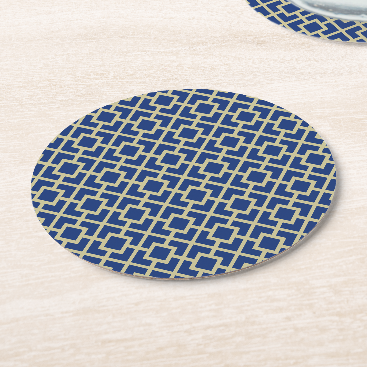 La Chinoiserie Cobalt Fretwork paper coasters on pale wood, cream lattice on cobalt