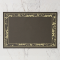 La Chinoiserie Bordure paper placemat in fawn — parchment engraved floral border on a deep umber ground