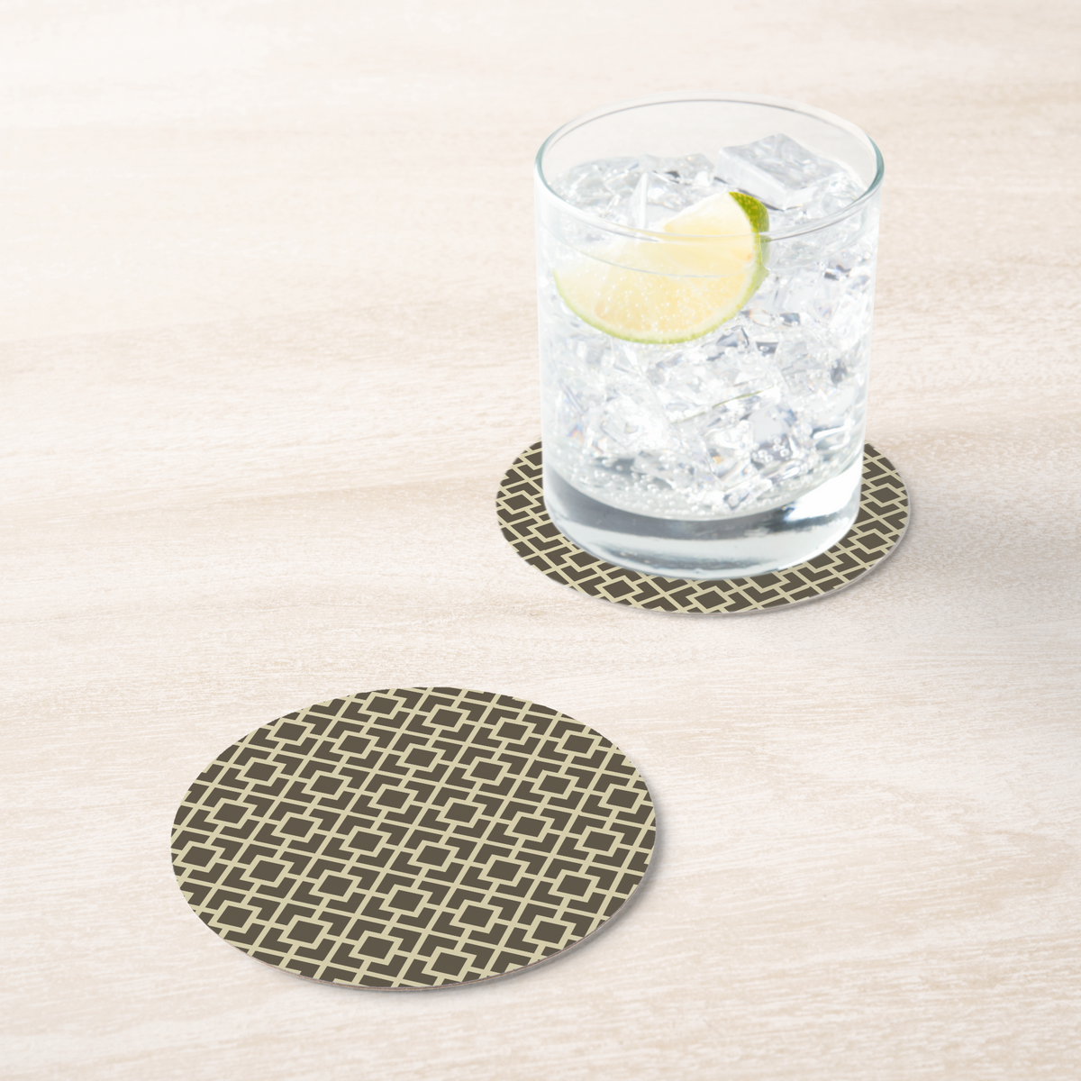 La Chinoiserie Fawn Fretwork paper coaster under an iced drink on pale wood