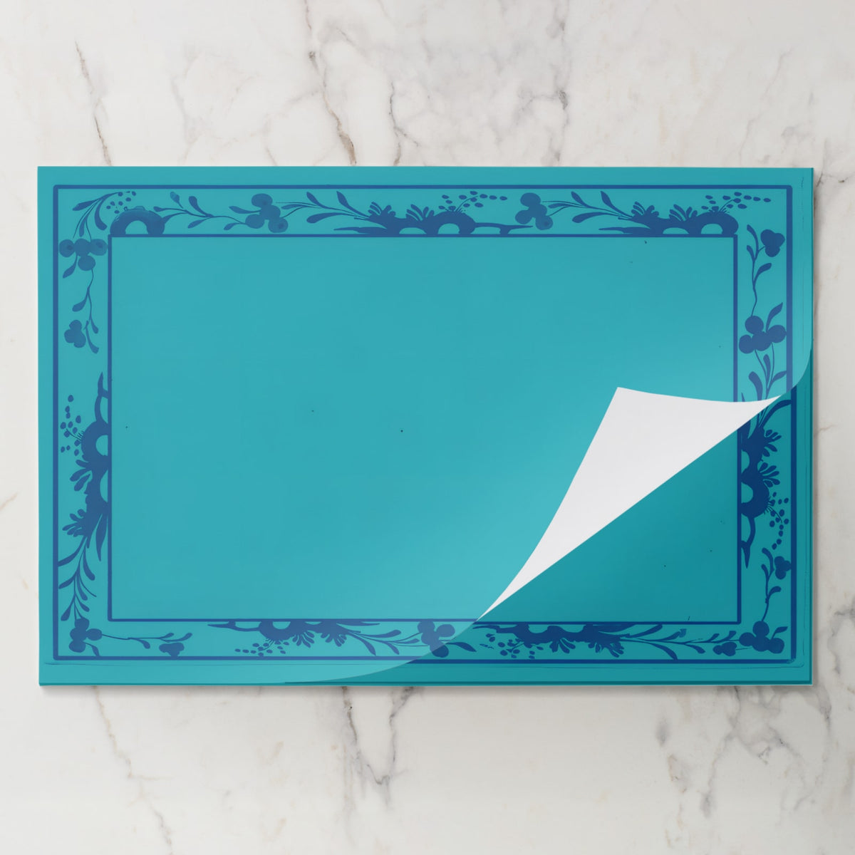 La Chinoiserie Bordure placemat pad in Lagoon, sheet lifted from the pad