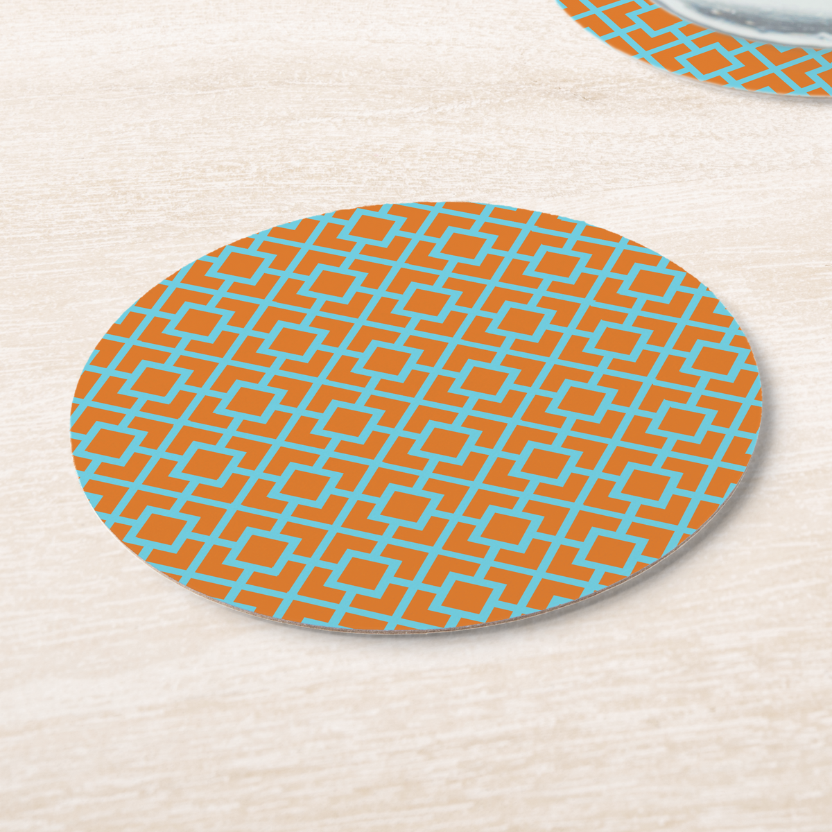 La Chinoiserie Orange Fretwork paper coasters on pale wood, aqua lattice on orange