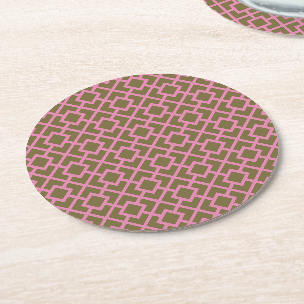 La Chinoiserie Pink Fretwork paper coasters on pale wood, pink lattice on olive