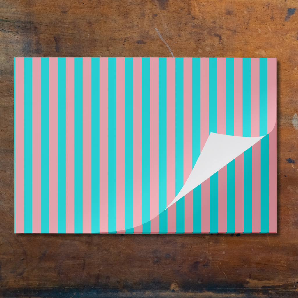 Striped paper placemat with pink and blue vertical stripes on a marble background