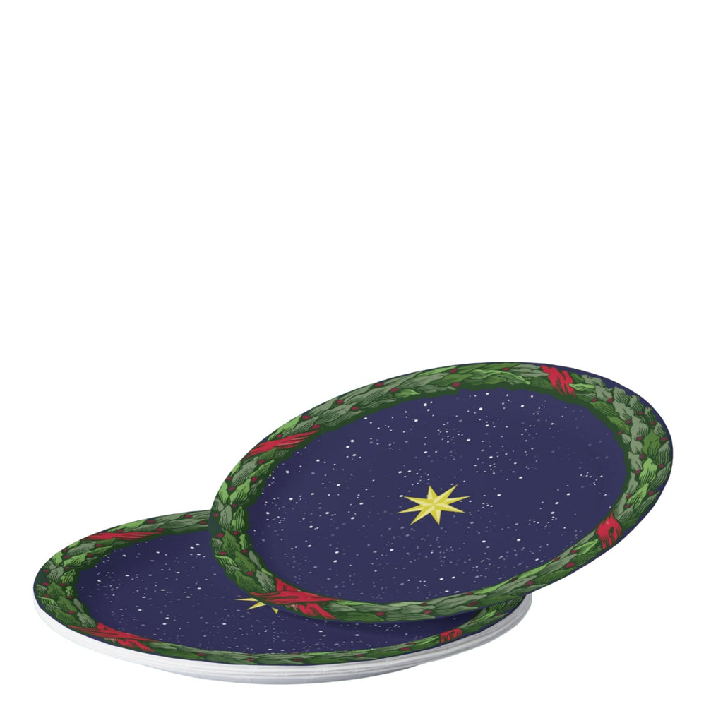 Noël La Nuit Étoilée plates on a set table — gold star on navy inside a green laurel wreath