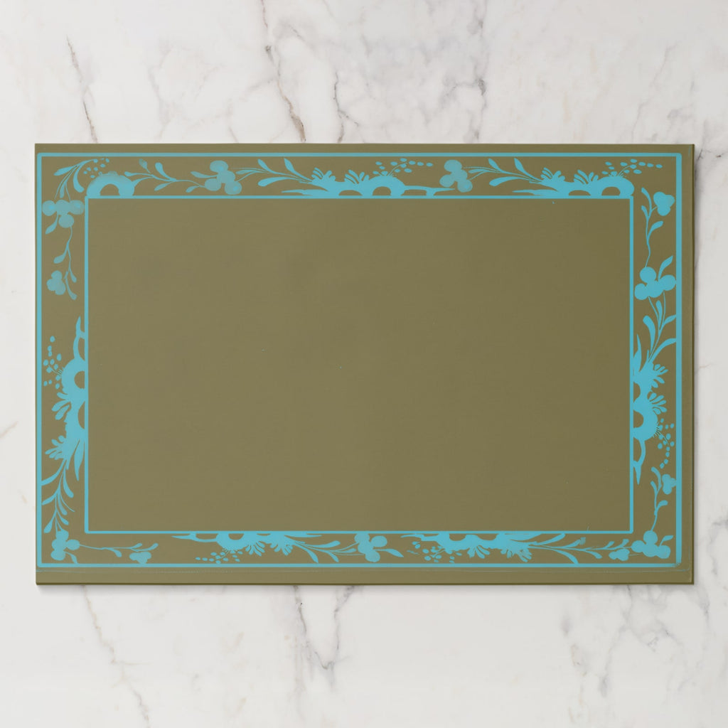 La Chinoiserie Bordure paper placemat in Teal — teal engraved floral border on olive, open centre