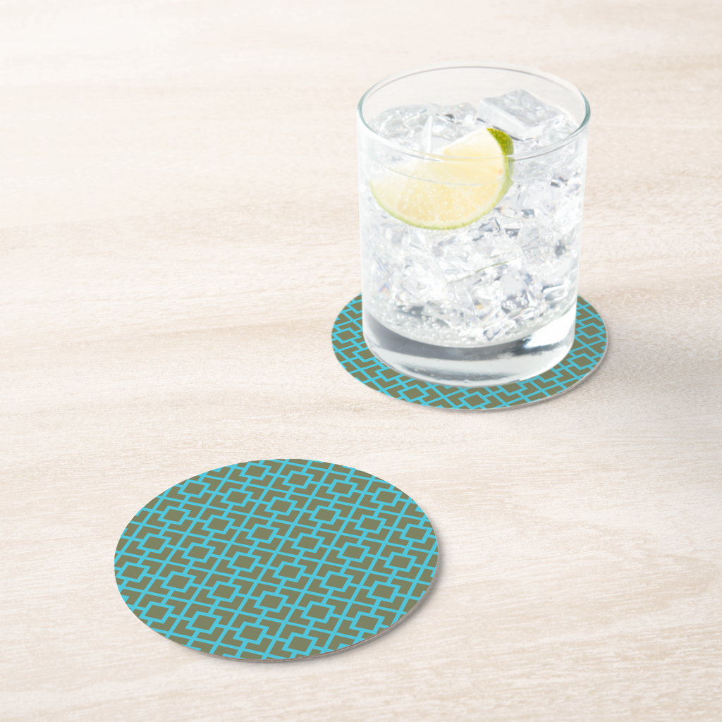 La Chinoiserie Teal Fretwork paper coaster under an iced drink on pale wood