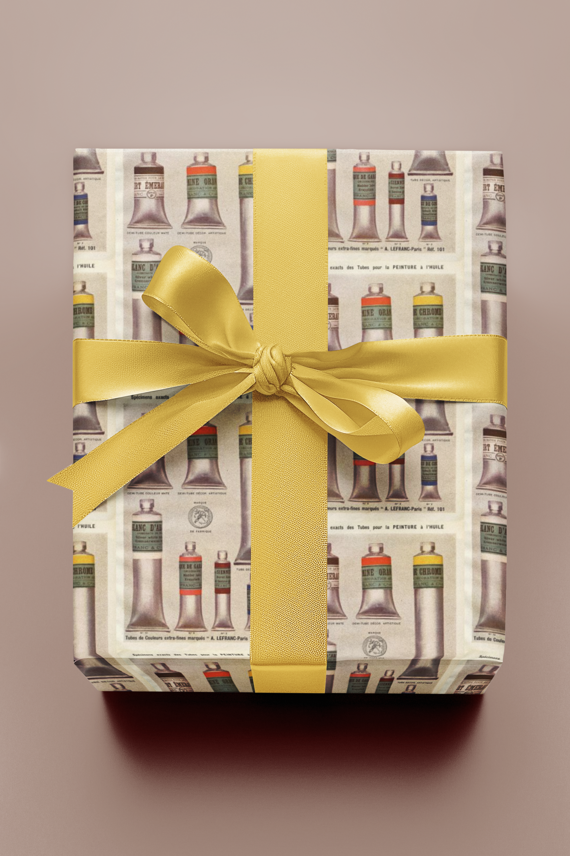 Gift box with yellow ribbon and patterned wrapping paper on a beige background